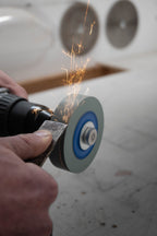 Chisel being sharpened using SharpStone 1.0 grinding disc mounted on a cordless drill, sparks flying